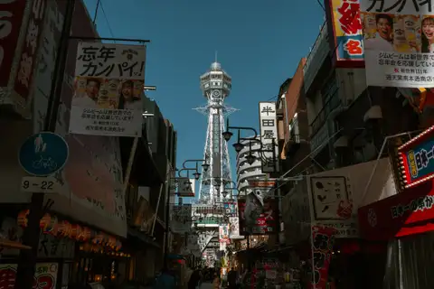 Tsutenkaku Tower rising above a crowded Osaka shopping street