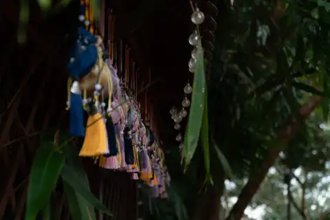 Colorful tassels and glass ornaments hanging beneath a dark wooden eave